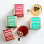 A collection of limited edition winter teas next to two prepared cups of tea