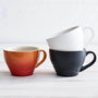 Trio of Le Creuset mugs in satin black, cotton, and volcanic